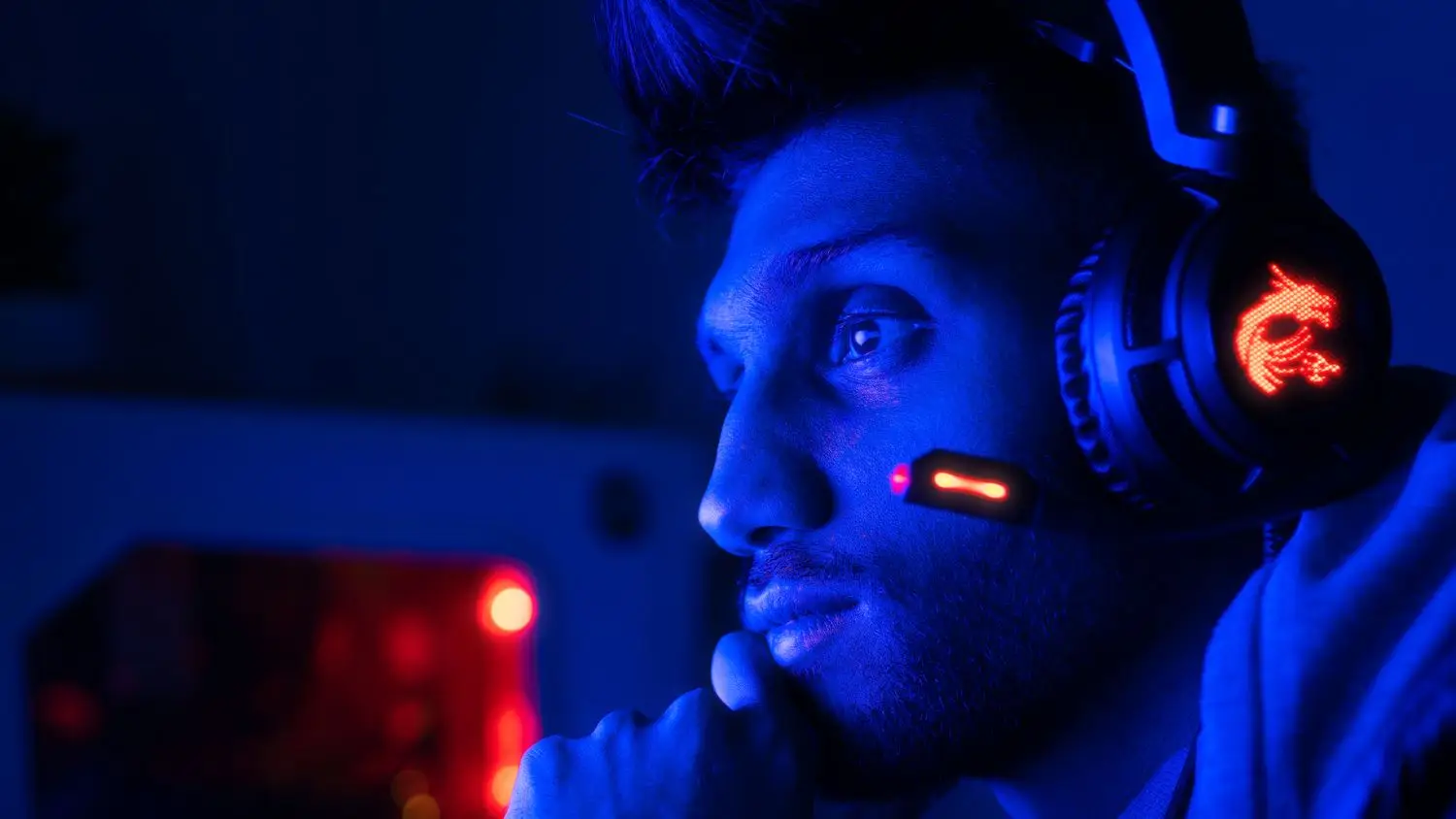 Streamer mit Headset in blauem Studiolicht